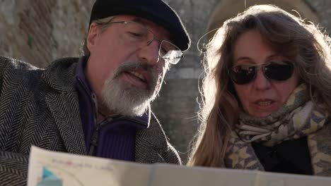 elderly couple exploring tourist map on street