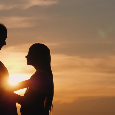 silhouettes of mother and daughter at sunset