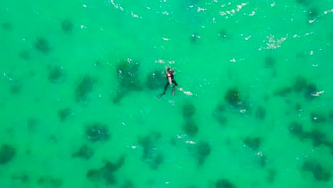 Eine-Wunderschöne-Aufsteigende-Antenne-über-Einem-Taucher,-Der-Im-Offenen-Tropischen-Meerwasser-Schwimmt