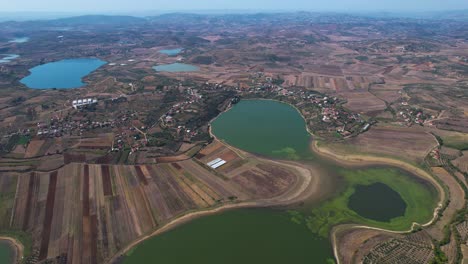 Dumre's-Natural-Lakes,-Brown-Lands,-and-Olive-Tree-Covered-Hills-in-a-Scenic-Agricultural-Village-Landscape-in-Albania