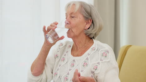 agua, píldoras y una mujer mayor en un sofá