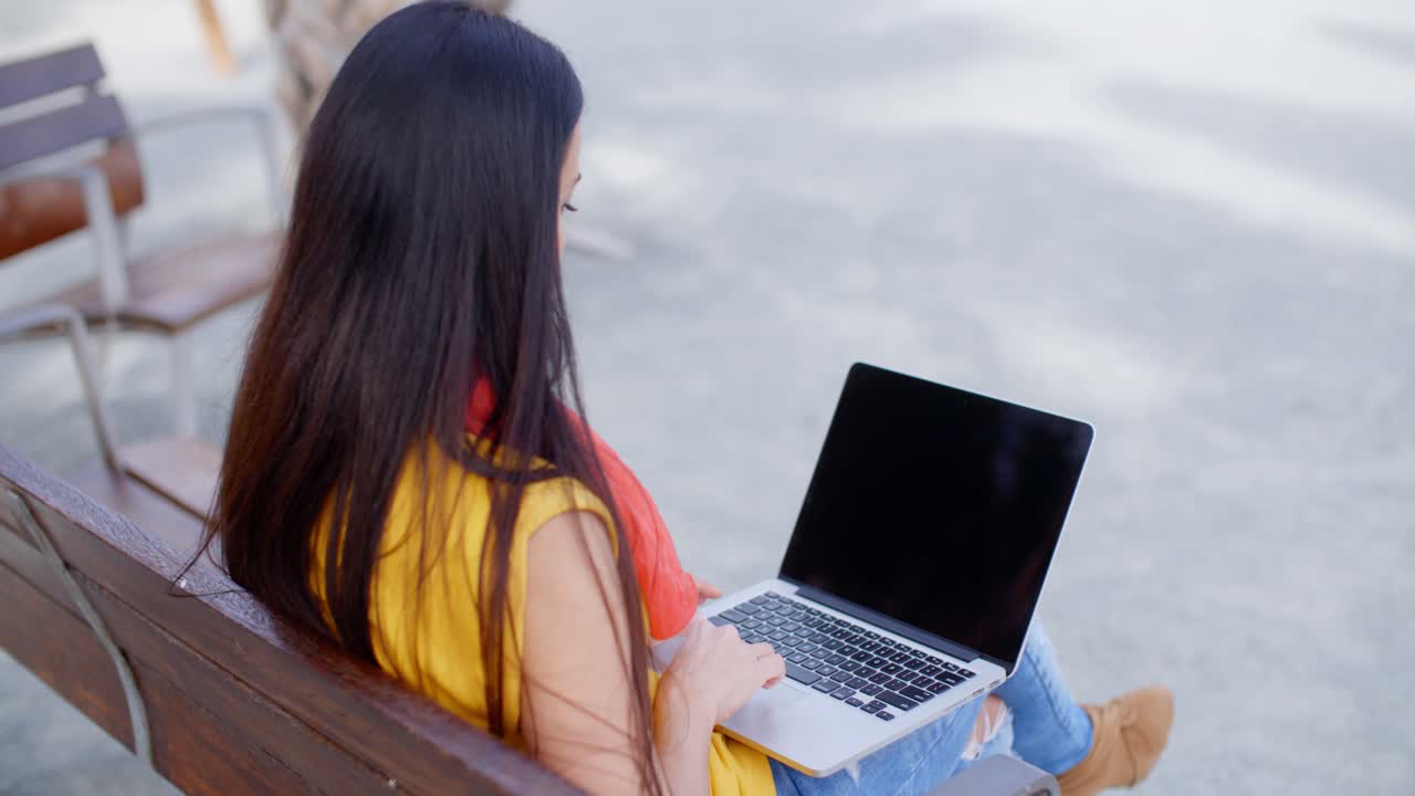 una mujer joven sentada en un banco urbano