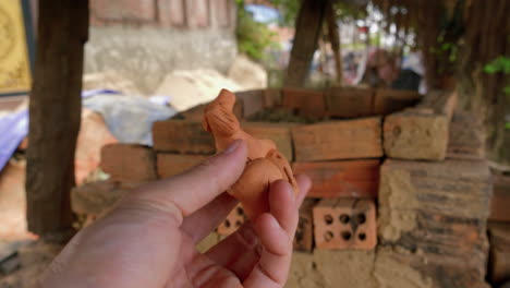 A-close-up-shot-of-a-traditional-clay-flute-from-Thanh-Ha,-a-souvenir-from-Vietnam,-as-a-hand-rotates-it-to-showcase-all-its-intricate-details