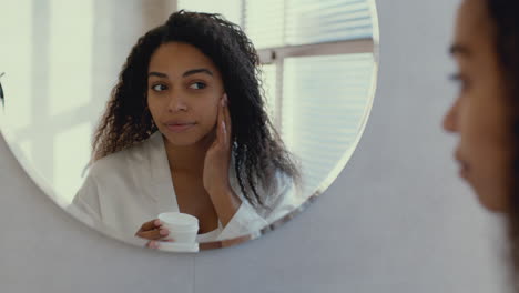 mujer aplicando crema facial