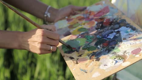 artist girl paints a picture outdoors