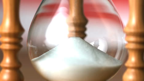 Sand-flowing-through-hourglass-with-american-flag-background-close-up