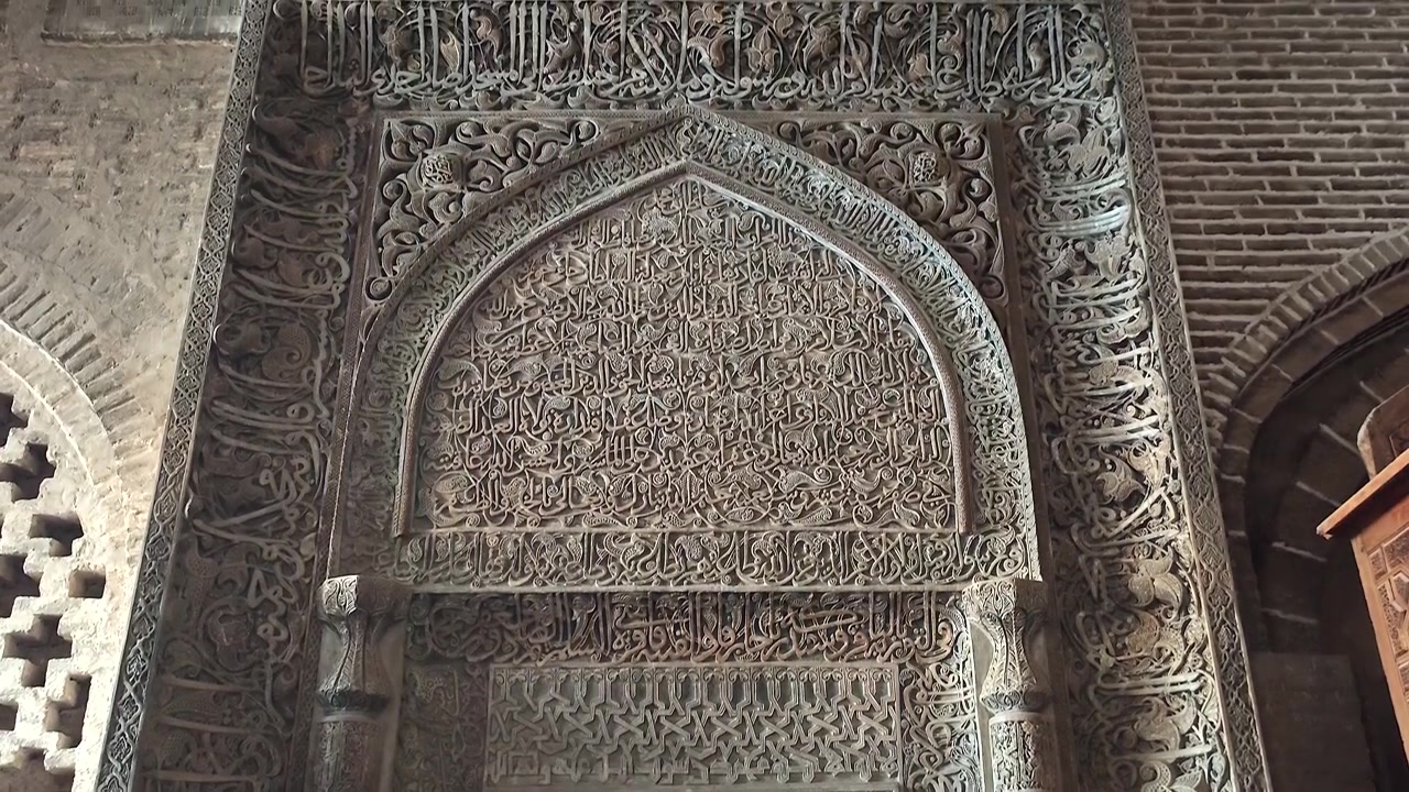Calligrafia islamica intricata scolpita in un mihrab di pietra
