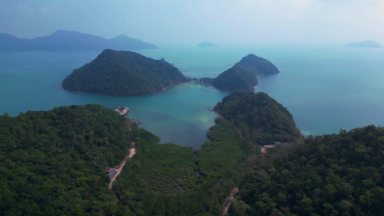 lush double mountain island with beach surrounded by turquoise sea and blue skies. Stunning aerial view flight speed ramp hyper motion time lapse