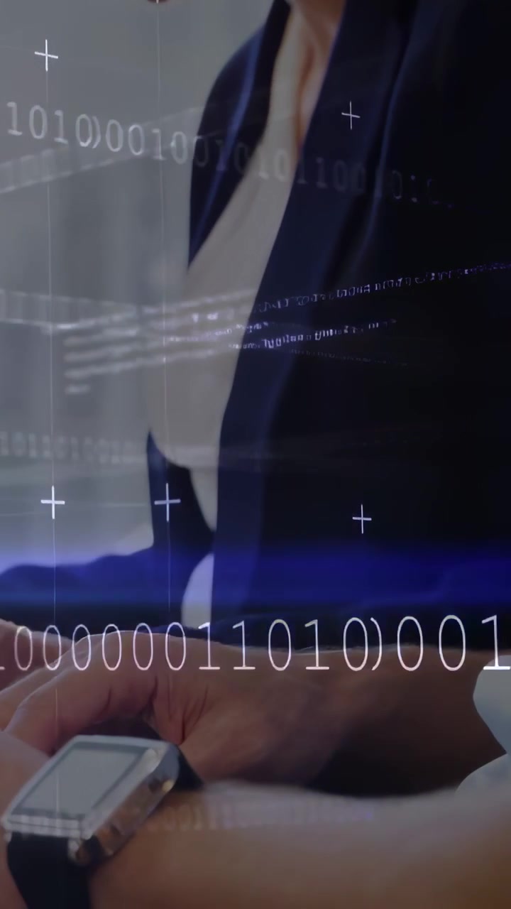 Video verticale: Uomo barbuto e donna che digitano per rivedere dati IT con un overlay binario in crescita.