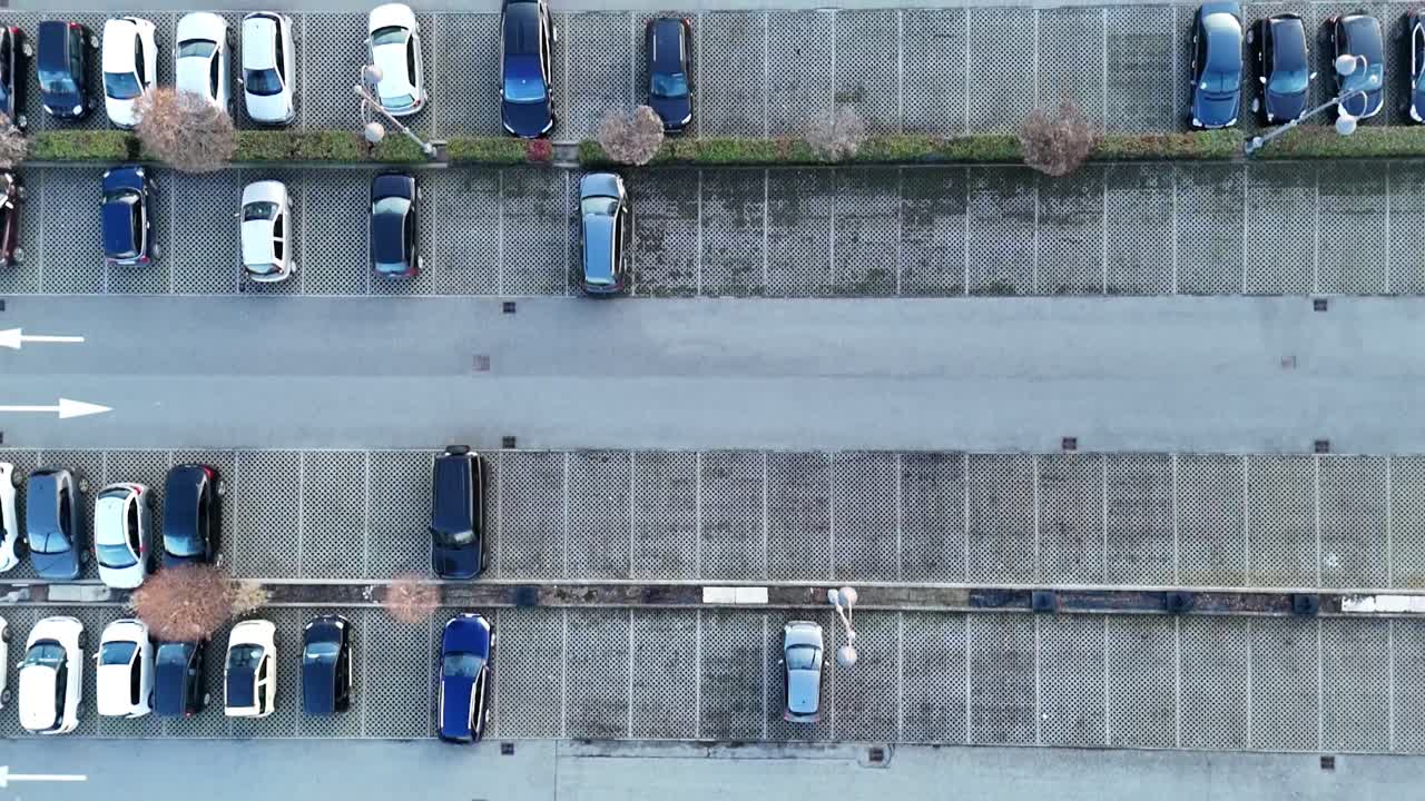 Oversiktsbilde av parkeringsanlegg som dokumenterer den fargerike symmetrien i detaljhandelsbasert infrastruktur