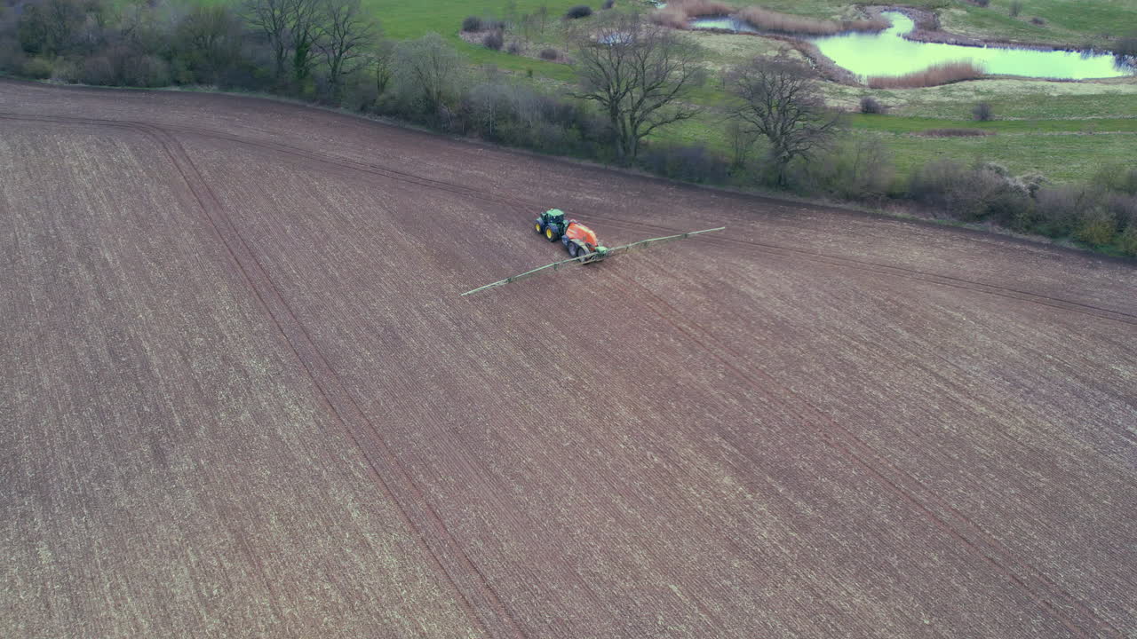 un tractor rociando fertilizante en un campo
