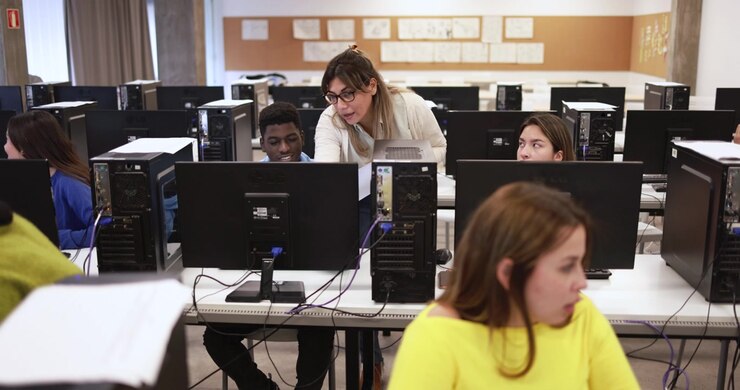 Teacher Assisting Student in Computer Lab Classroom