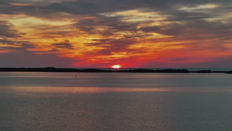 sun setting over florida near dunedin beach drone view