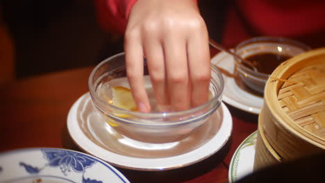 a girl uses a water finger bowel with lemon at a chinese restaurant