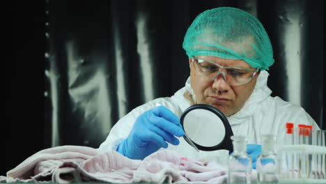 crime lab worker examines evidence on clothes 8