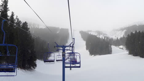 chairlift with skiers and snowboarders at a ski resort in alberta, canada