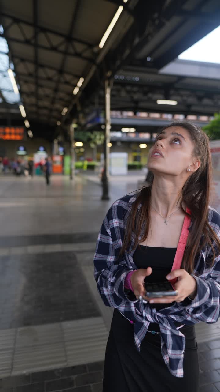 Giovane donna in attesa alla stazione ferroviaria