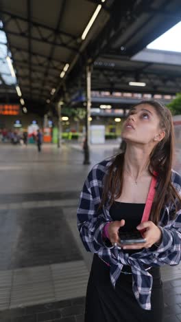 young woman waiting at train station