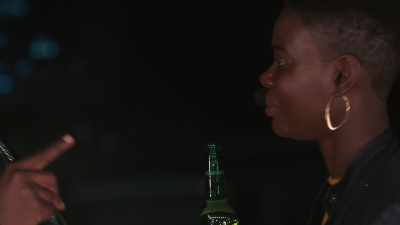 giovani amici che passano il tempo sul tetto di notte a chiacchierare a conversare a godersi la serata urbana un uomo afroamericano che flirta con una bella donna in un appuntamento