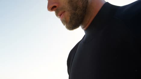 Male-surfer-standing-in-the-beach