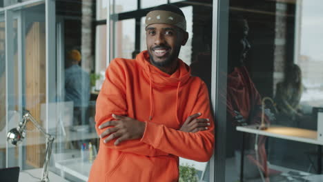 man in an orange hoodie in a modern office