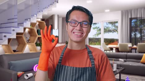 primer plano de una ama de casa asiática con un delantal mostrando un gesto de ok y sonriendo mientras está de pie en la casa
