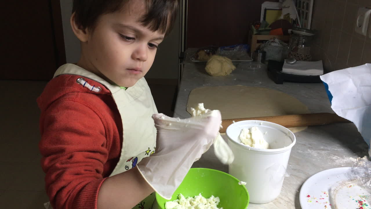 primer plano de un niño triturando queso feta en un tazón