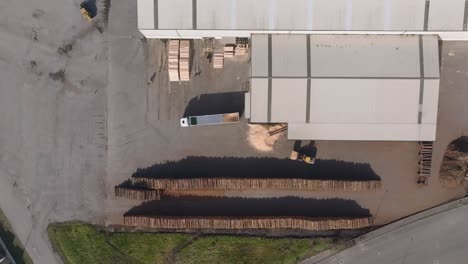 loader loading truck with wood chips at industrial sawmill