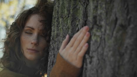 caucasian adult woman bonding to tree in the park.