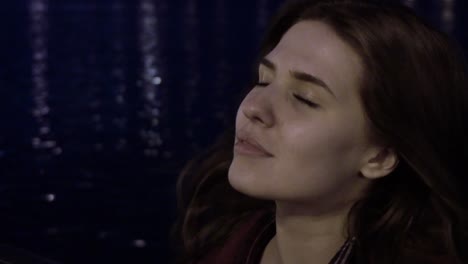 woman relaxing near a fountain at night