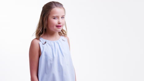 girl walks into shot and winks against white background