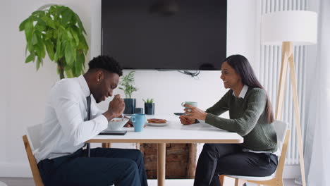 business couple at home eating breakfast before leaving for work