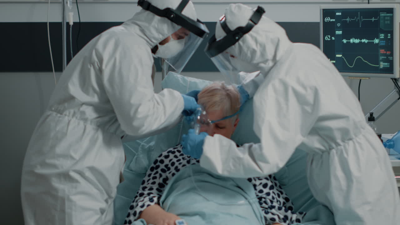 Team of paramedics in hazmat suits helping sick patient