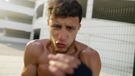 boxeador practicando puñetazos en frente de la cámara al aire libre