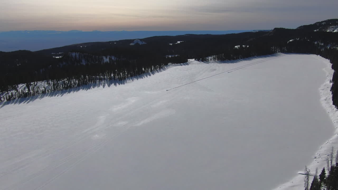 Un drone traccia 2 motoslitte su un lago ghiacciato in Colorado