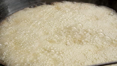 closeup of rice in boiling water in a big wok at a street market in thailand