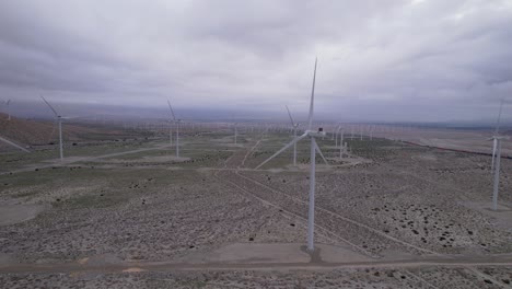 Aerial-footage-of-a-wind-farm-in-the-Palm-Springs-desert-on-a-cloudy-day,-slow-horizontal-dolly-shot