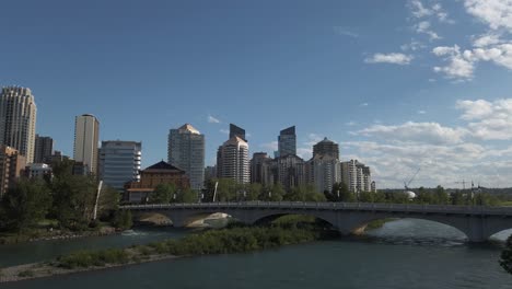 city bridges pan over the river with skyscrapers on a sunny day calgary alberta canada