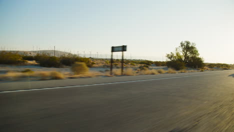 palm springs windmills spinning early morning with the road and rugged san jacinto mountains rising behind them in california