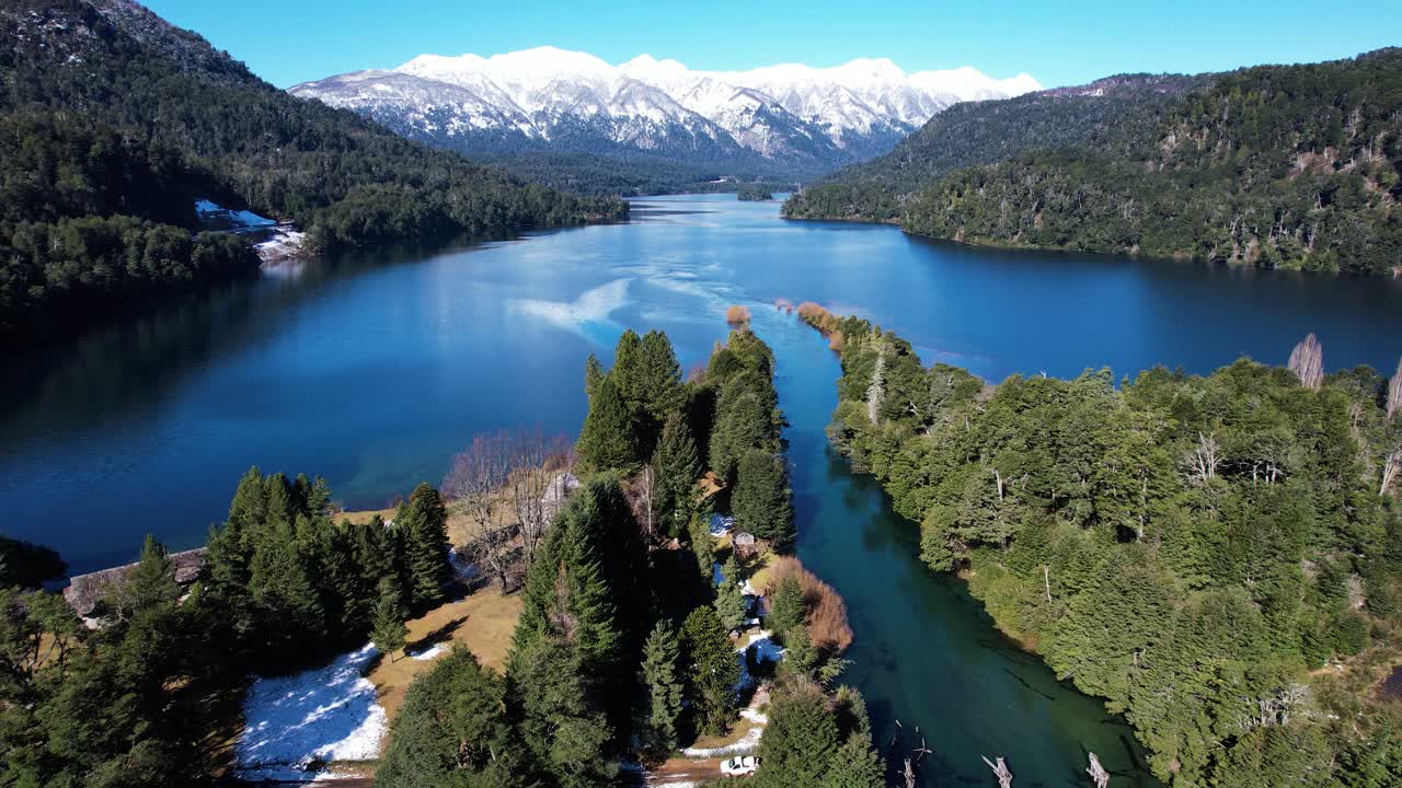 montañas nevadas sobre el agua del lago azul en argentina, vista aérea