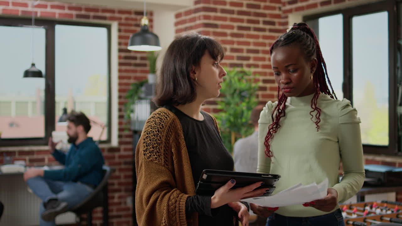 Diverse team of coworkers looking at research on digital tablet
