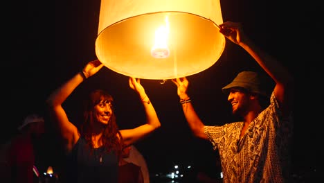 Couple releasing sky lanterns at night