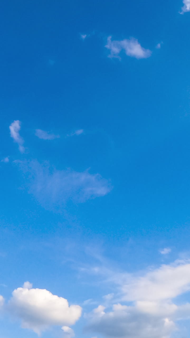 Amazing clear azure sky in summer. Cumulus clouds covering the horizon and sun. Low angle view. Timelapse. Vertical video