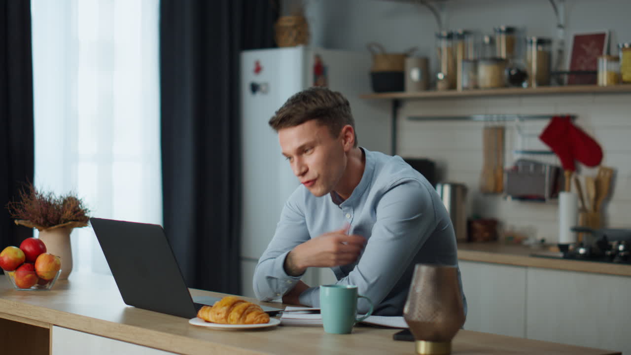 Guy speaking video call with girlfriend sitting at kitchen. Man using web chat.