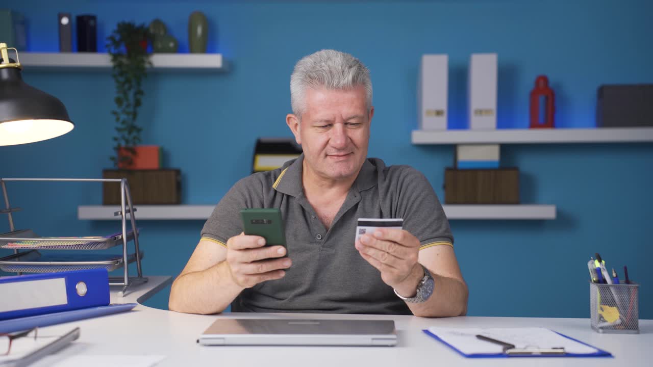Uomo in smart working che fa acquisti al telefono