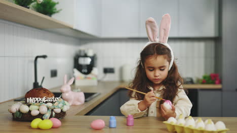 Little Girl Painting Easter Eggs in the Kitchen
