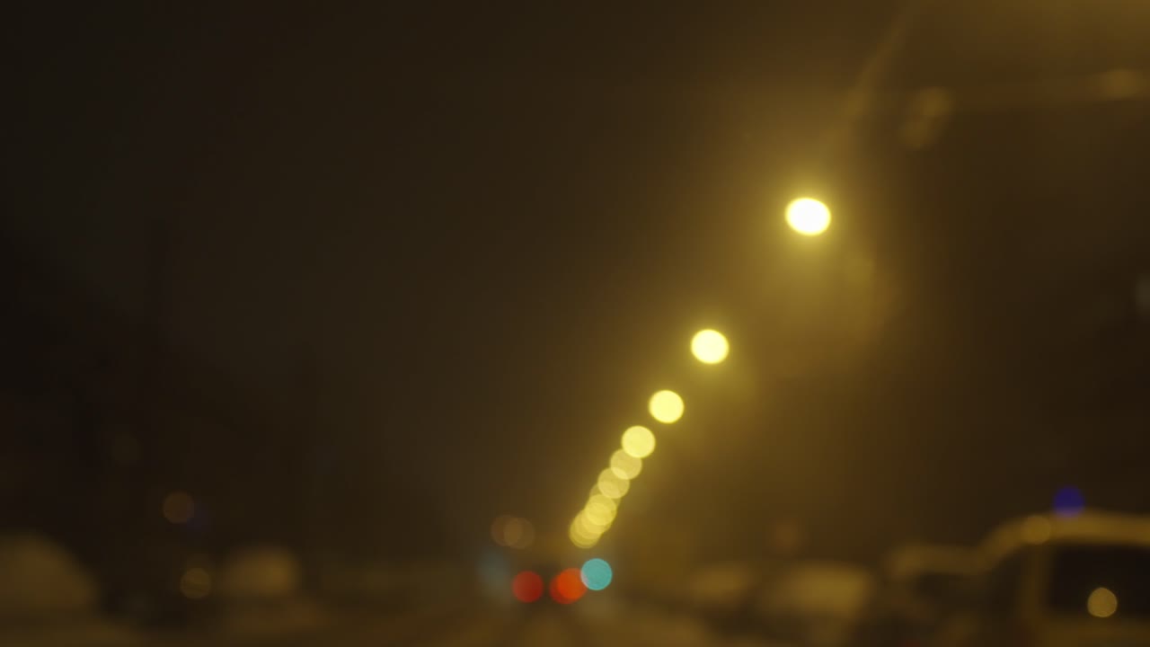 luces de calles de color amarillo que brillan por la noche, conducción, vista borrosa