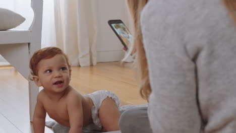 Madre-Tomando-Una-Foto-Del-Bebé-Usando-Un-Teléfono-Inteligente-Disfrutando-Fotografiando-A-Un-Lindo-Niño-Pequeño-Compartiendo-El-Estilo-De-Vida-De-La-Maternidad-En-Las-Redes-Sociales