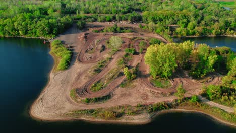 Erstaunliche-Offroad-Motocross-Strecken-Aus-Der-Luft-Neben-Einem-See-Und-Einem-Wald