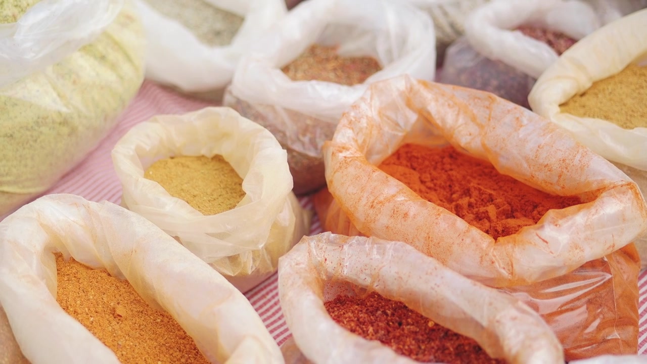 Variety of Colorful Powdered Spices Displayed in Plastic Bags